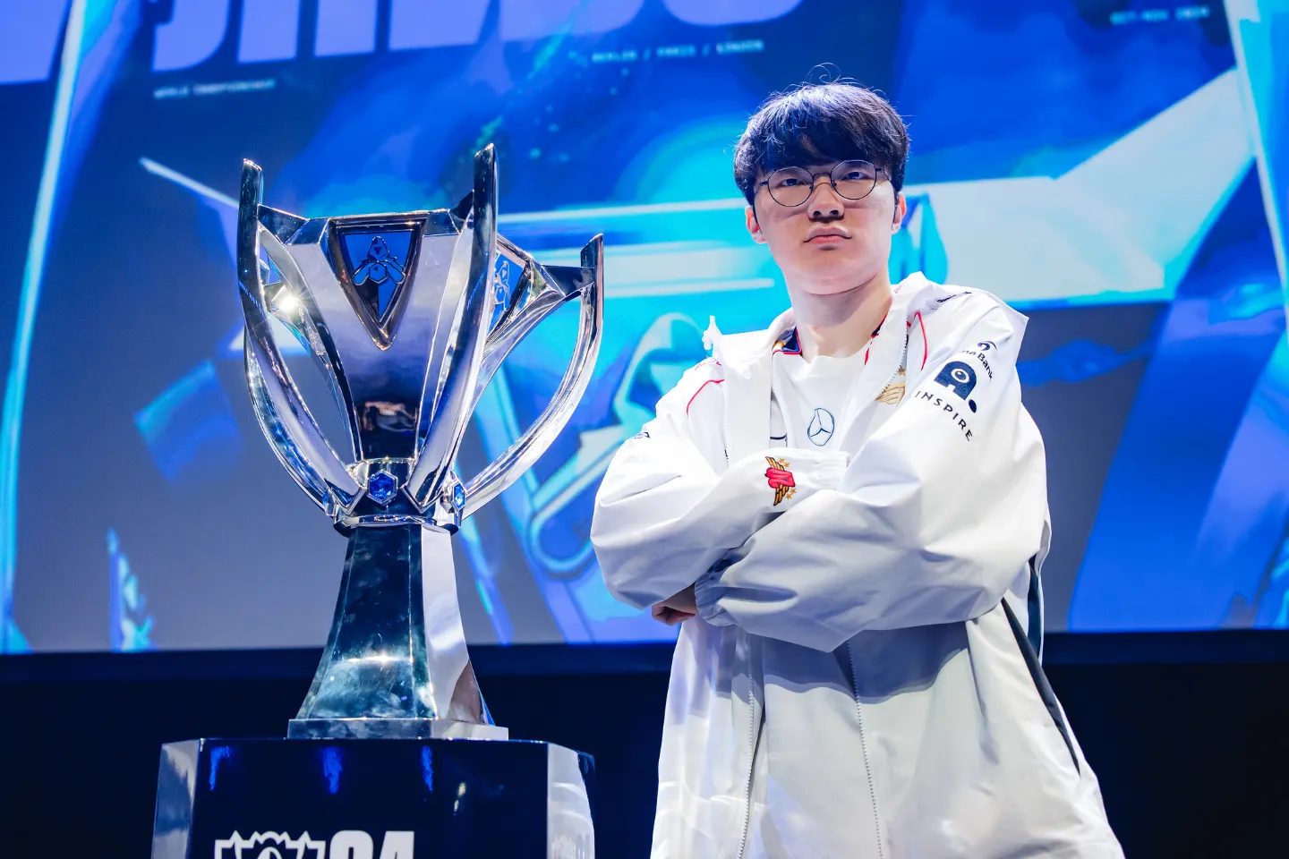 Faker of T1 poses with trophy onstage at the League of Legends World Championship 2024